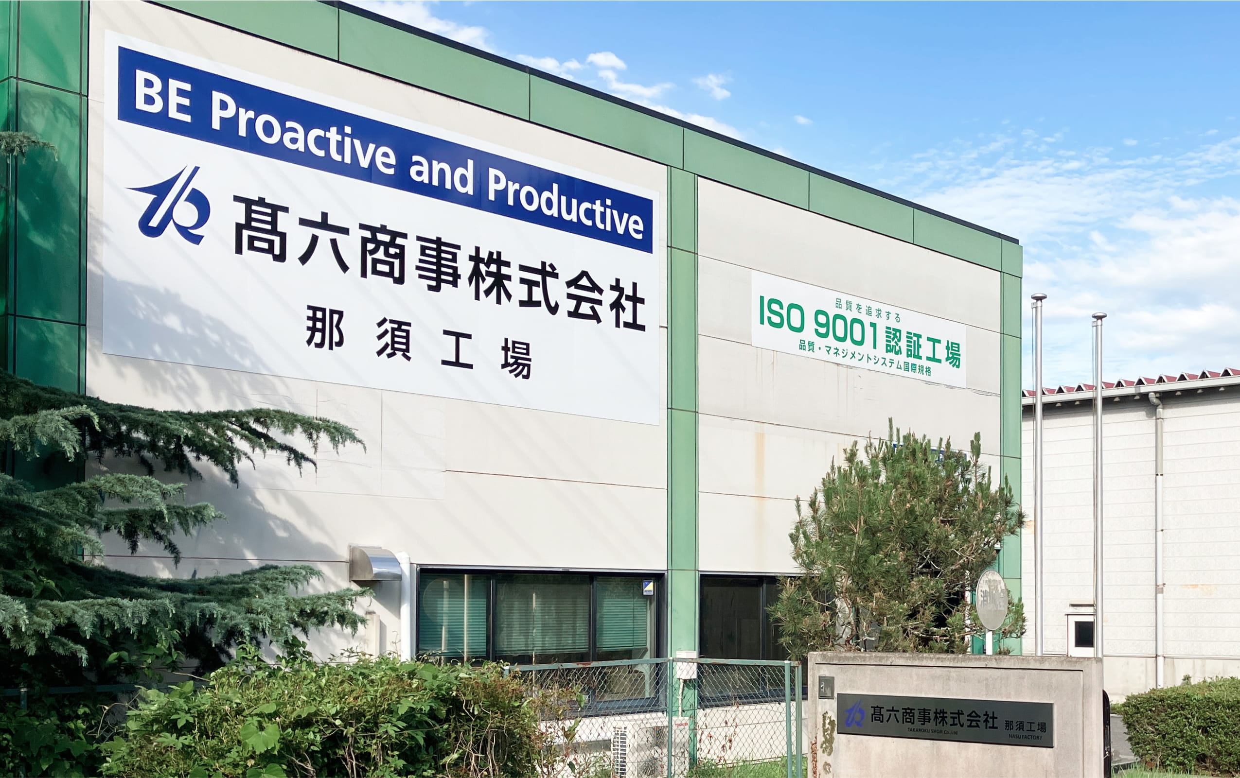 高六商事株式会社の那須工場の外観。建物には「BE Proactive and Productive」と書かれた看板がある。